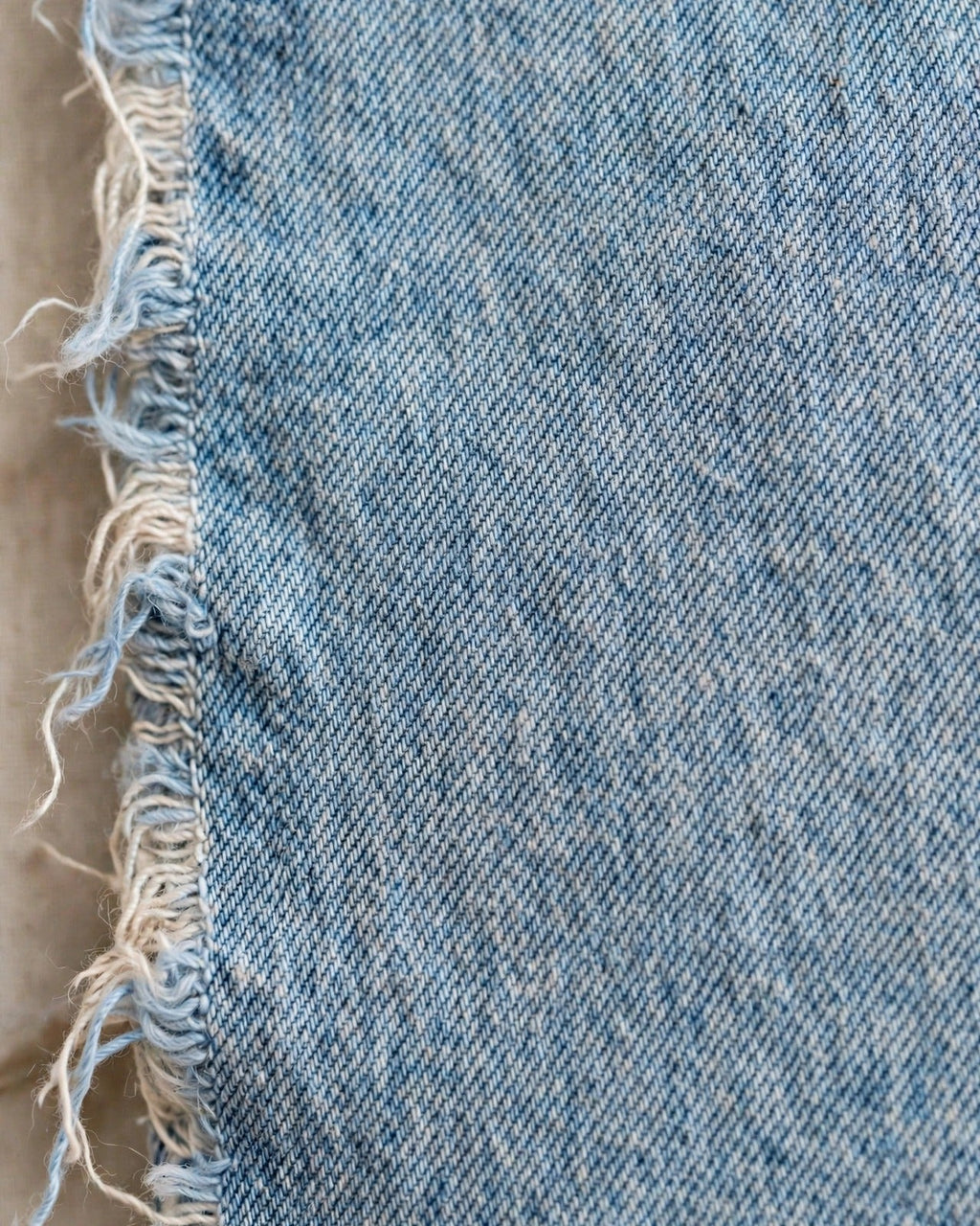 Light denim tote with small red patch letters – denim fabric texture close-up
