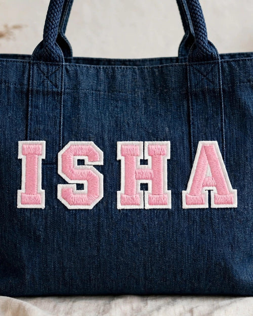 Dark denim tote with ISHA in pink chunky patch letters