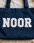 Dark denim tote with NOOR in white chunky patch letters