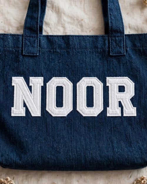 Dark denim tote with NOOR in white chunky patch letters