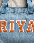 Light denim tote with RIYA in orange chunky patch letters