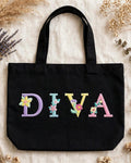 Black canvas tote with DIVA in pastel floral embroidered alphabet letters