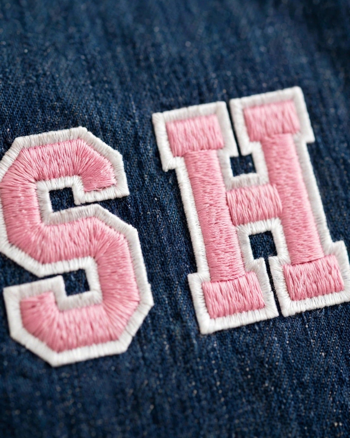 Dark denim tote with small pink patch letters – embroidery close-up