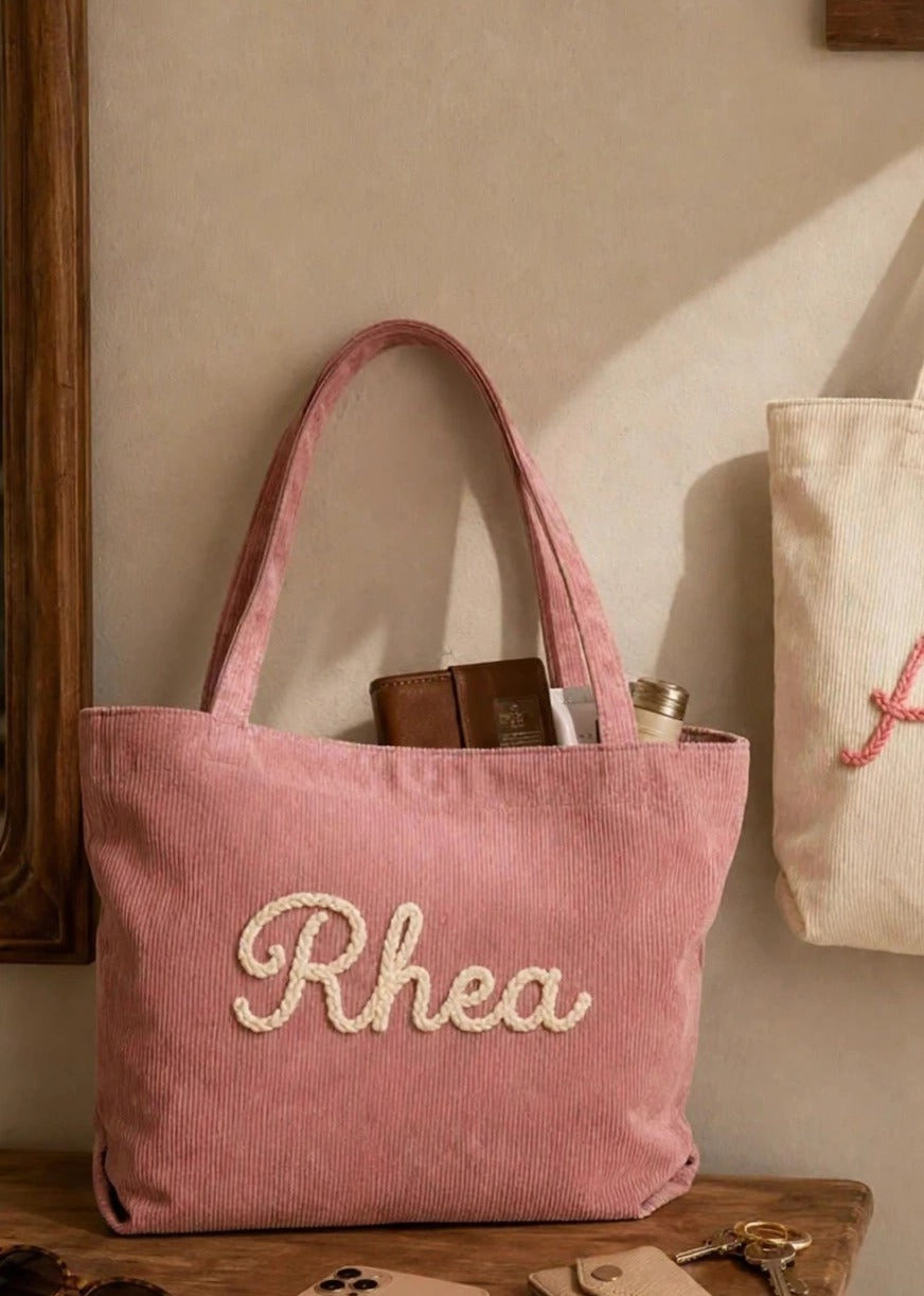 Example: "Rhea" name hand-embroidered on pink corduroy tote
