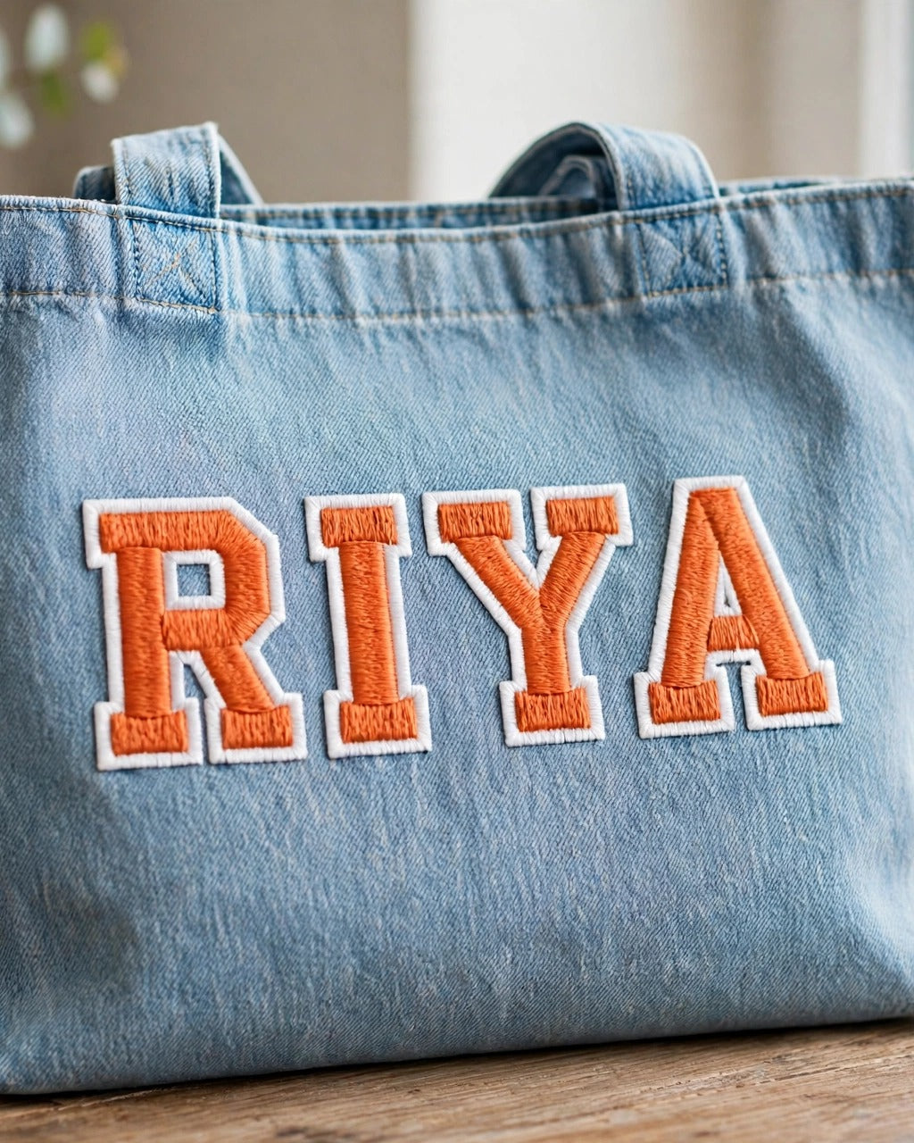 Light denim tote with small orange patch letters – lifestyle shot