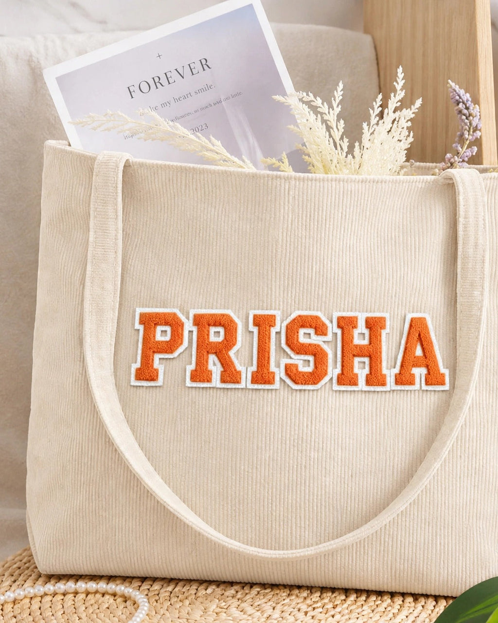 Cream corduroy tote with PRISHA in orange embroidered varsity patch letters
