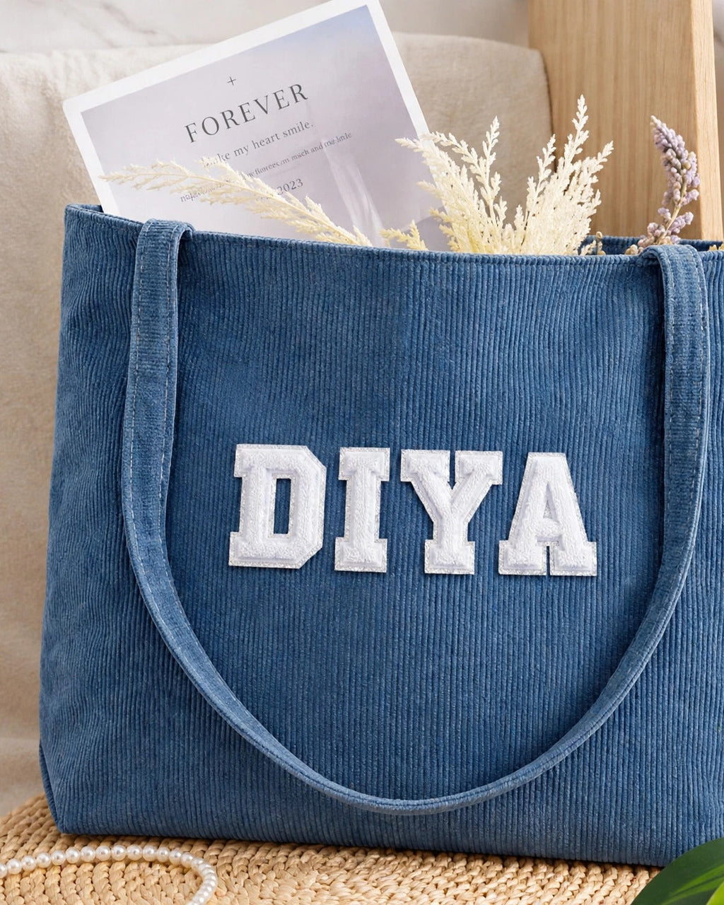 Denim blue corduroy tote with DIYA in white embroidered varsity patch letters