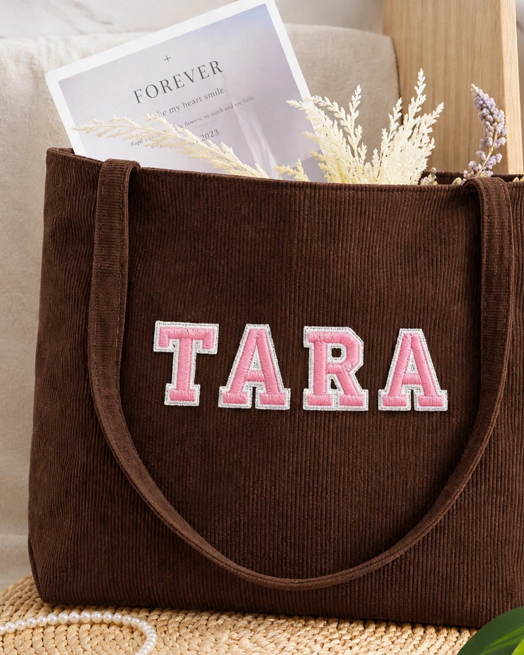 Chocolate brown corduroy tote with TARA in pink embroidered varsity patch letters