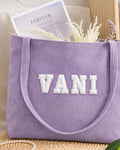 Lavender corduroy tote with VANI in white embroidered varsity patch letters
