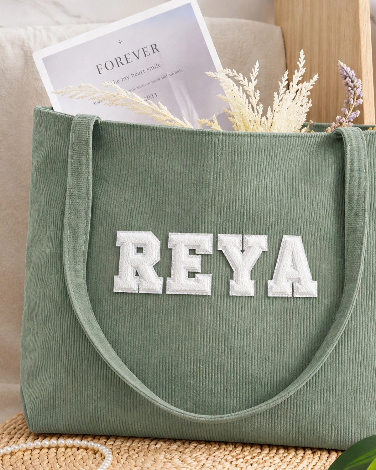Sage green corduroy tote with REYA in white embroidered varsity patch letters